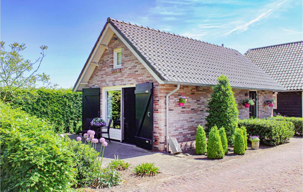 una pequeña casa de ladrillo con una puerta negra en Amazing Home In Udenhout With House A Panoramic View, en Udenhout