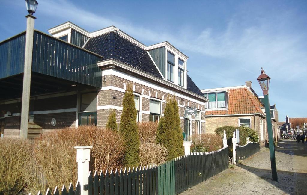 ein großes Haus mit einem Zaun und einer Straßenbeleuchtung in der Unterkunft De Eekhof - Appartement 8 in Hindeloopen