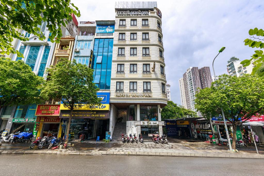 a tall white building on a city street at Yolo Wa Hotel in Hanoi