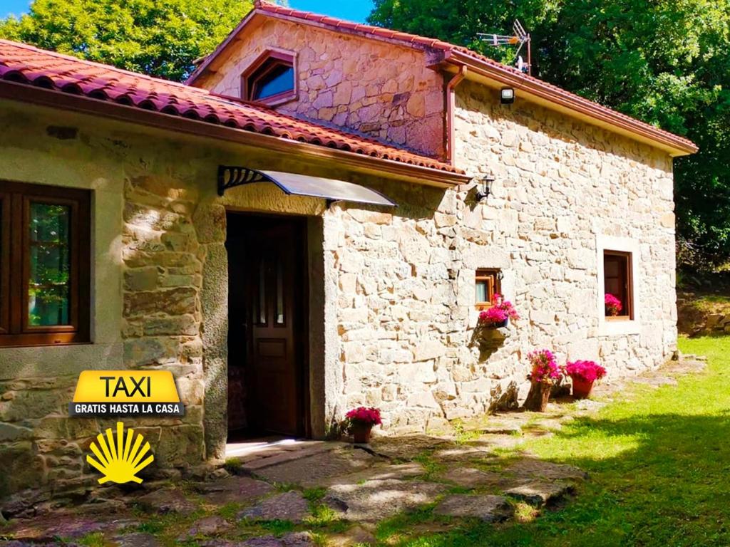 una casa de piedra con un cartel delante en Casa do Castiro, en Palas de Rei 