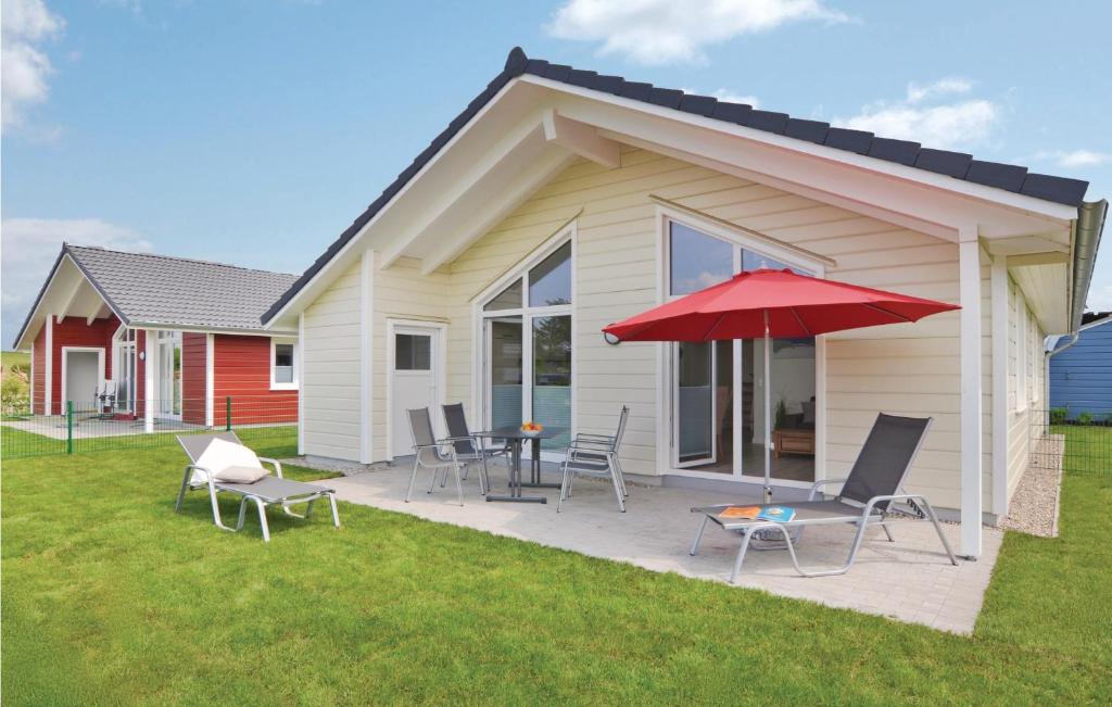 Casa con patio con sillas y sombrilla roja en 2 Bedroom Nice Home In Dagebüll, en Dagebüll