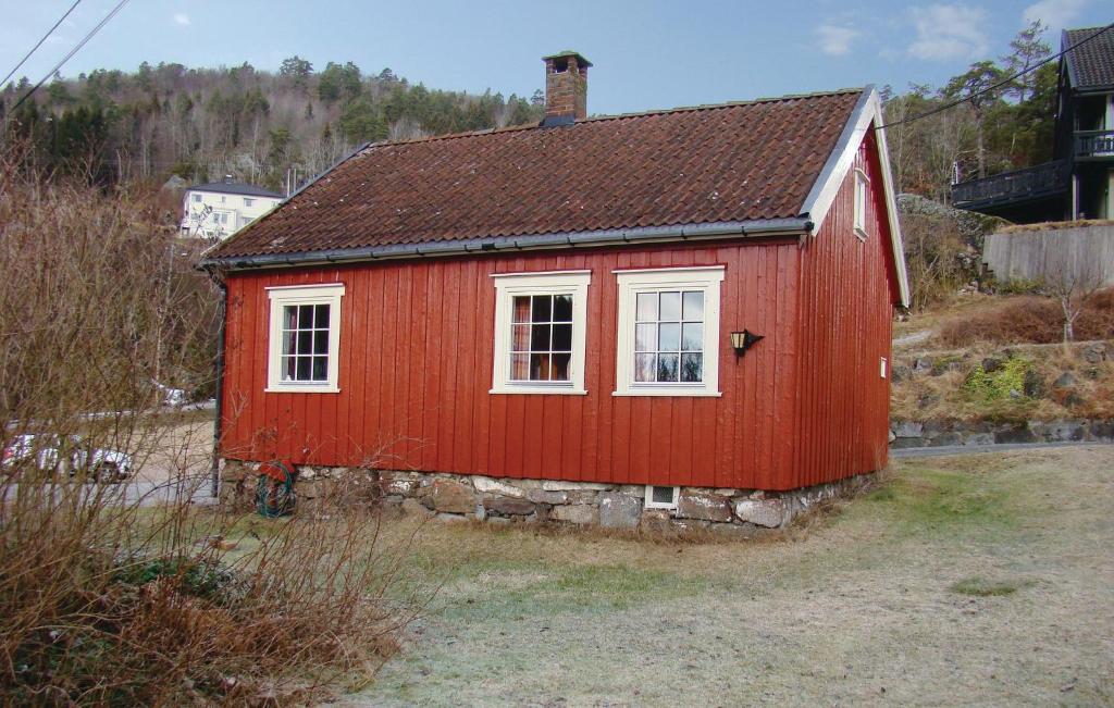 a red small house with a white window at Tangen in Langangen