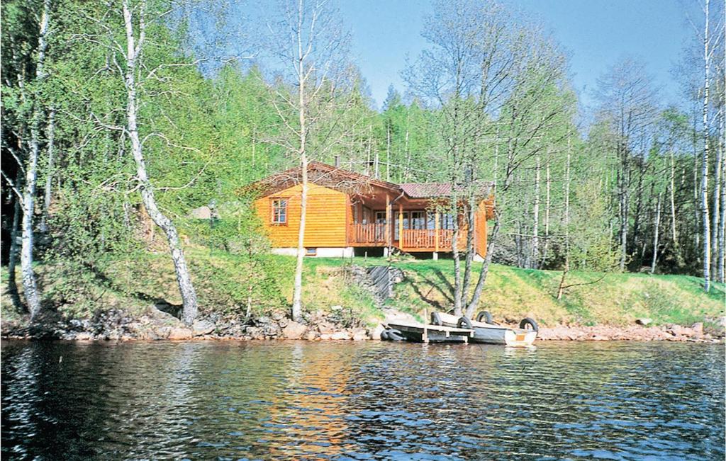 Nice Home In Gislaved With 2 Bedrooms, Sauna And Wifi في Våthult: منزل خشبي كبير على شاطئ البحيرة
