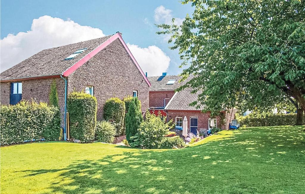 a red brick house with a green yard at Seven-Bedroom Holiday Home In Remersdaal in Remersdaal