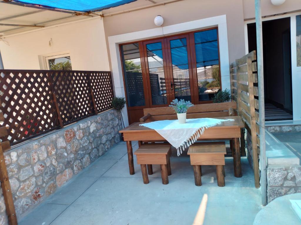 a wooden table and benches on a patio at Manolakis Pizanias in Emborios