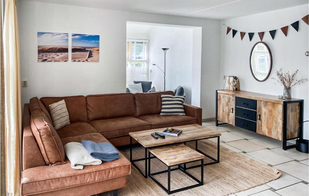 a living room with a brown couch and a table at It Soal Waterpark-waterlelie in Workum