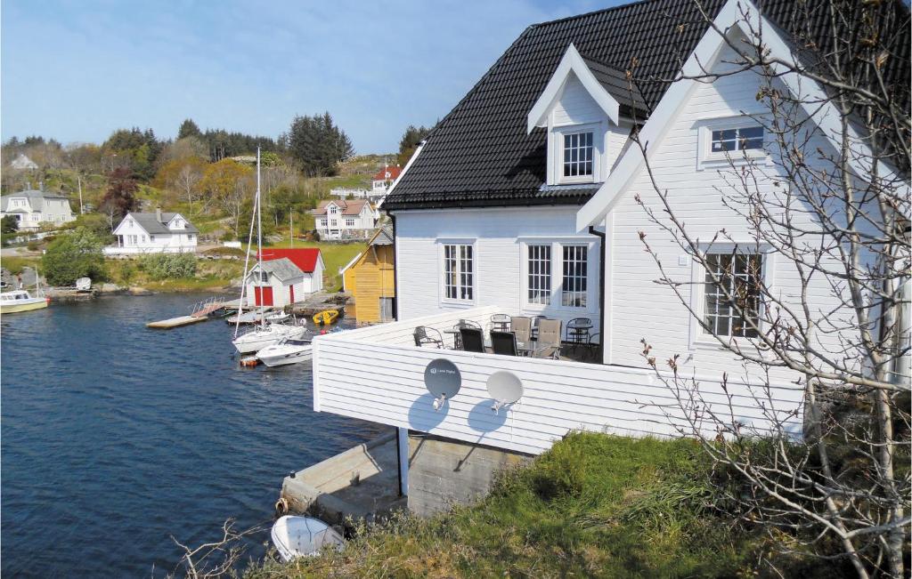 a white house next to a body of water at Beautiful Apartment In Steinsland With 4 Bedrooms And Wifi in Hommelsund