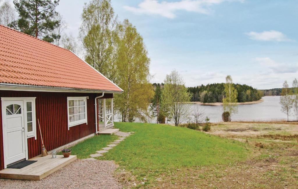 uma casa vermelha com um telhado vermelho ao lado de um lago em Cozy Home In Karlstad With Wifi em Killstad