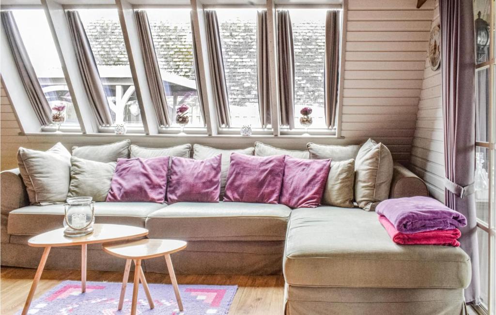 ミッデルケルケにあるMarijkeの窓付きの客室で、ソファ(紫色の枕付)