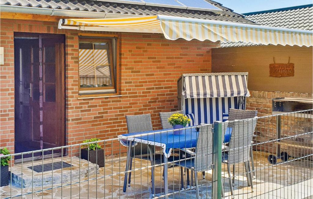 a patio with a table and chairs in front of a house at Lovely Home In Wurster Nordseekste With Kitchen in Heuhausen