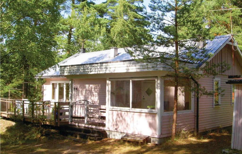 una pequeña casa rosa con porche en Nice Home In Yngsj With 2 Bedrooms, en Yngsjö