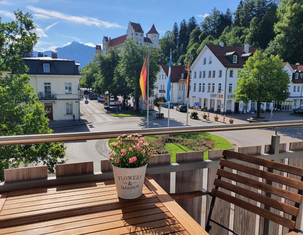 a potted plant sitting on a bench on a city street at Bergzeit Füssen - Ferienwohnung in Füssen