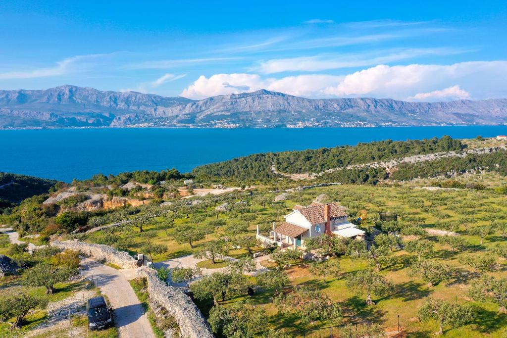 an aerial view of a house on a hill next to a lake at House Marina in Postira
