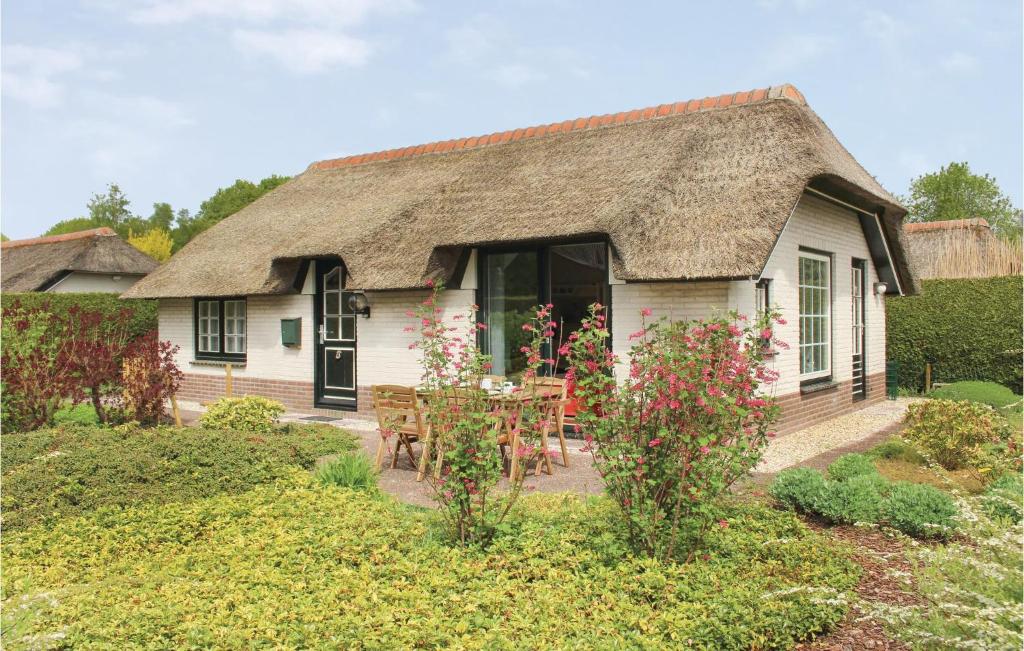 een klein wit huis met een rieten dak bij 2 Bedroom Beautiful Home In Ermelo in Ermelo
