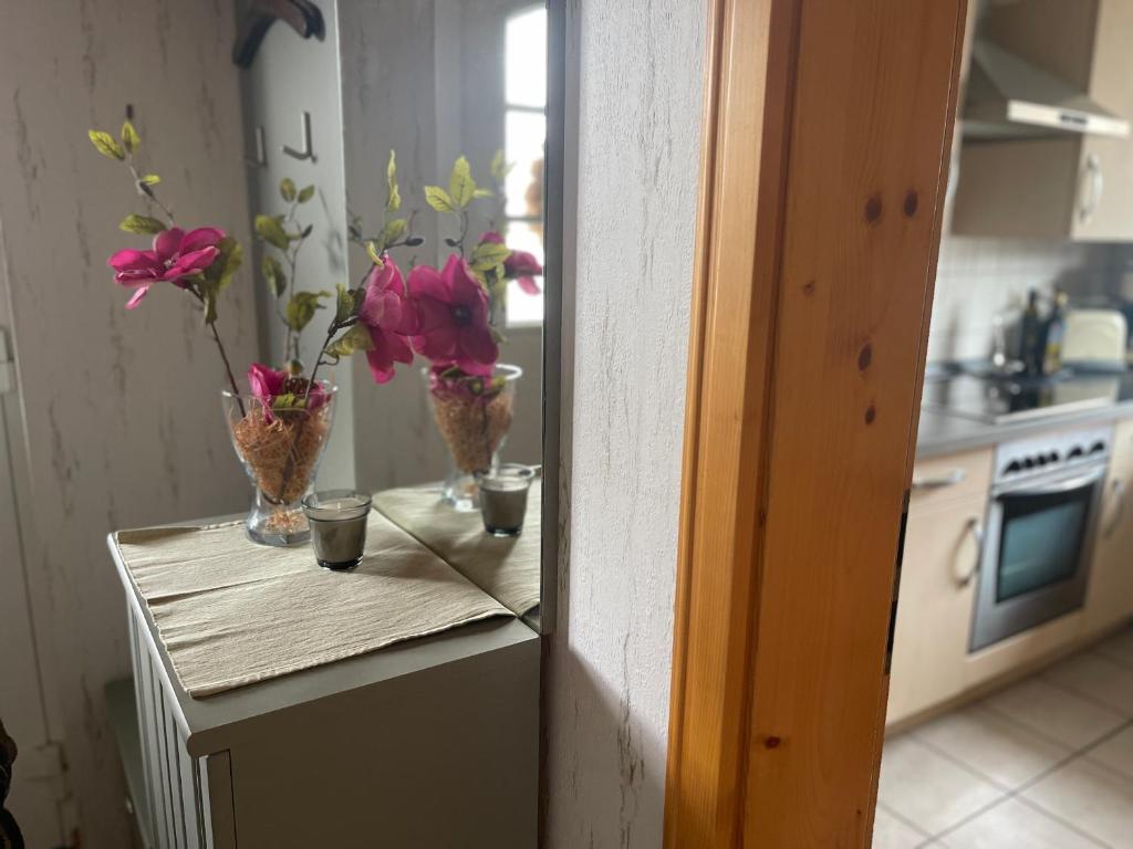 a counter with vases of flowers in a kitchen at Ferienwohnung Käthchen in Stendal