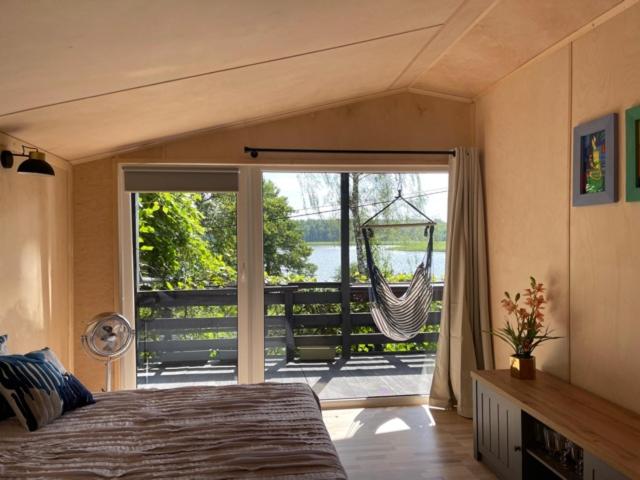 a bedroom with a bed and a sliding glass door at Domek nad jeziorem in Gietrzwałd