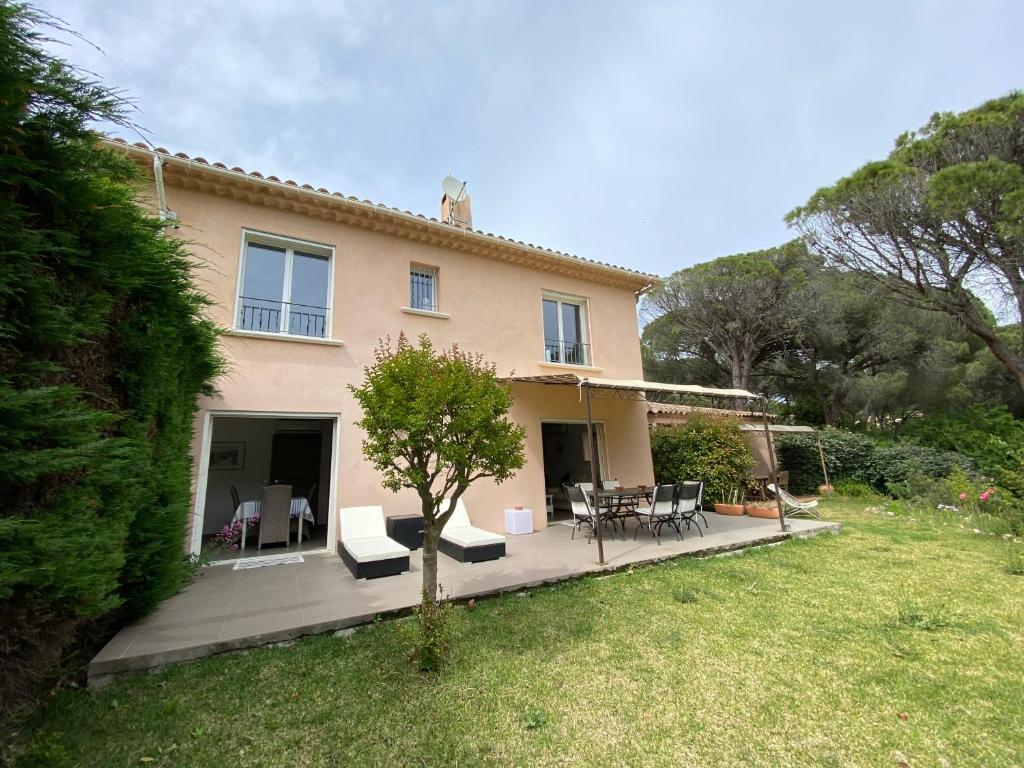 une maison avec une terrasse, une table et des chaises dans l'établissement VILLA Saint Raphael Valescure Piscine Clim Wifi Golf, à Saint-Raphaël