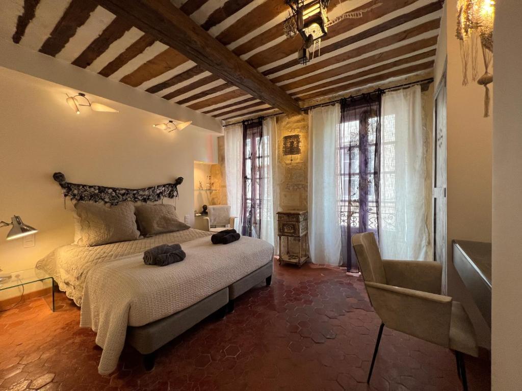 a bedroom with a bed and a chair in it at Le Regardeur in Saint-Rémy-de-Provence