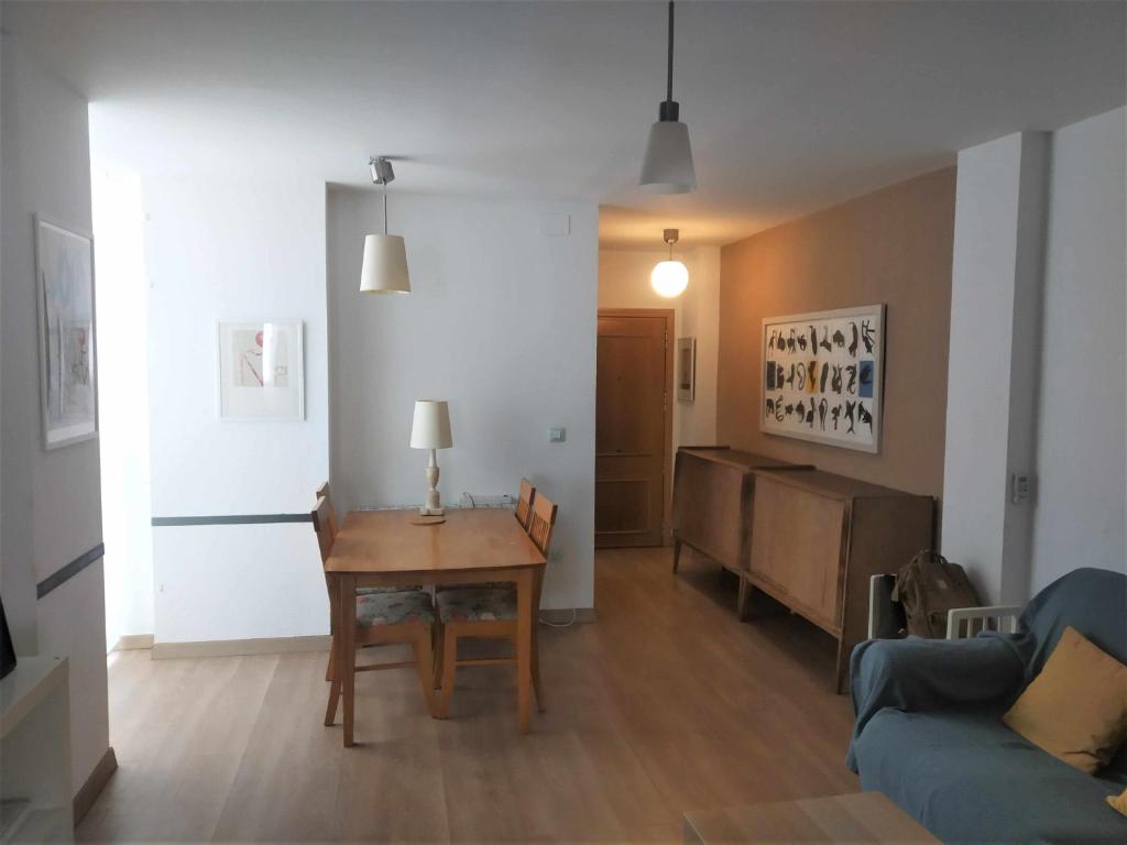 sala de estar con mesa y sofá en Acogedor apartamento en el Rabal en Zaragoza