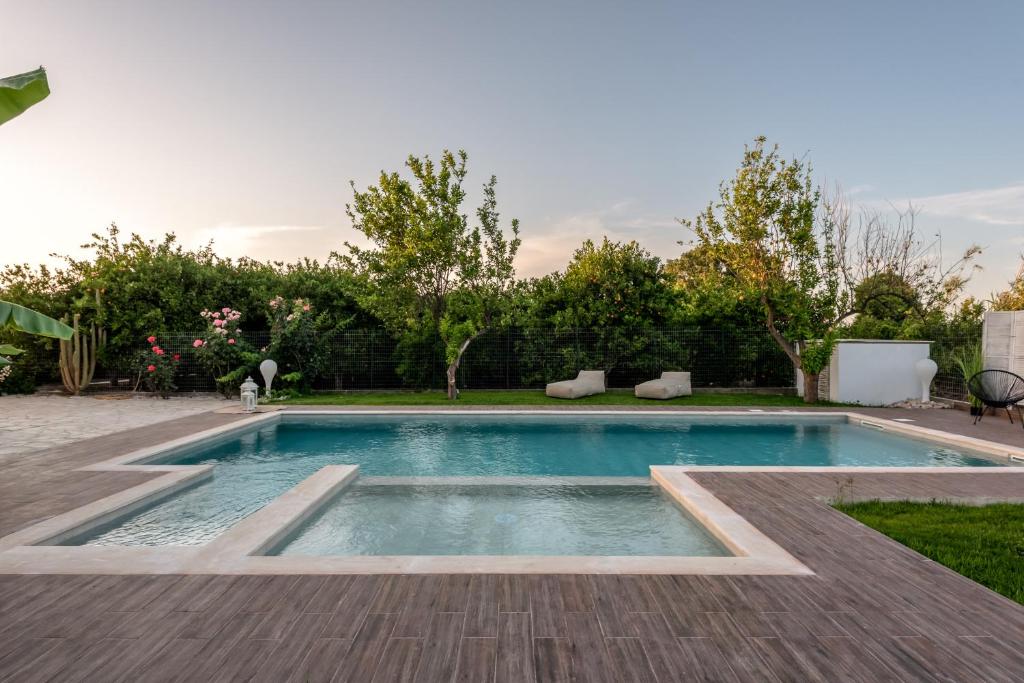 una piscina in un cortile con terrazza in legno di Elenas Village house - Dream apt w Pool & Terrace a Alikianós