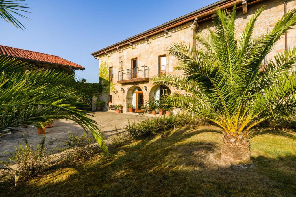 a palm tree in front of a building at Palacio Garcia Quijano in Los Corrales de Buelna