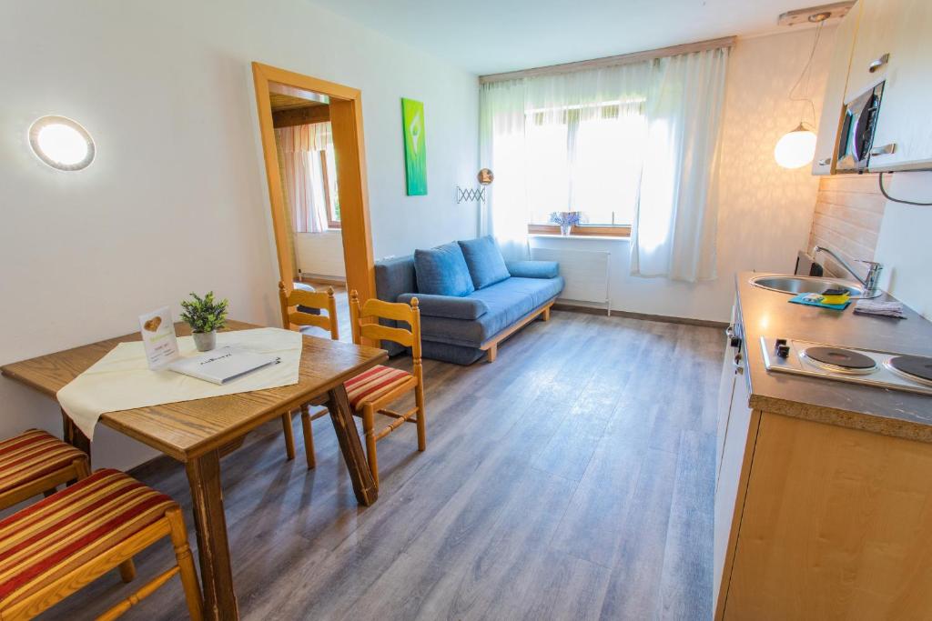 eine Küche und ein Wohnzimmer mit einem Tisch und einem Sofa in der Unterkunft Huberhof 2 by Alpenidyll Apartments in Schladming