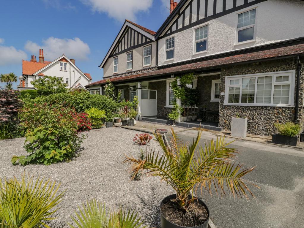 ein Haus mit einer Topfpflanze im Vorgarten in der Unterkunft 18 Tyn Celyn in Llandudno