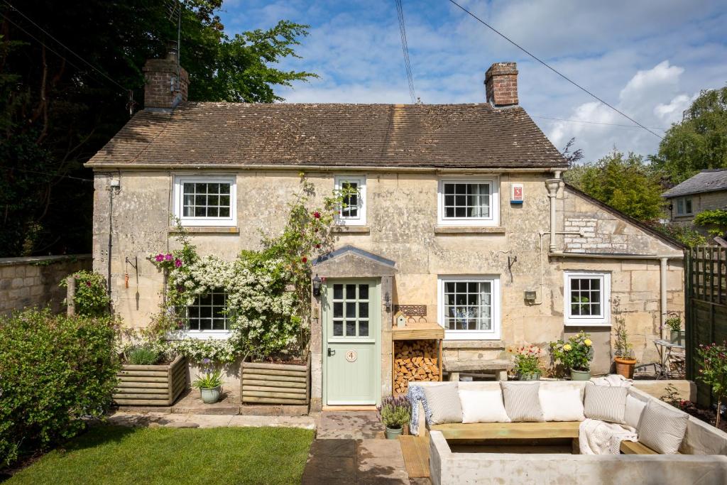 een oud stenen huis met een groene deur bij Mulberry, A Luxury Two Bed Cottage in Painswick in Painswick