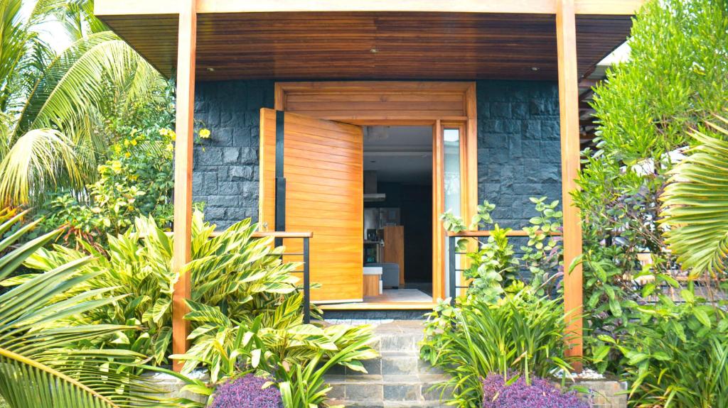 a house with a wooden door in a garden at Modern Design Villa - Trou aux Biches in Trou aux Biches