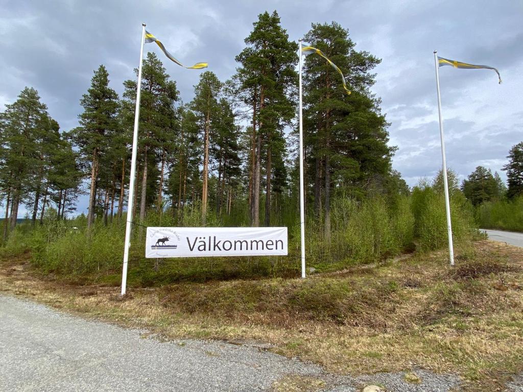 d'un panneau apposé sur le côté d'une route avec drapeaux dans l'établissement Camping Fredrika-Braber, à Fredrika