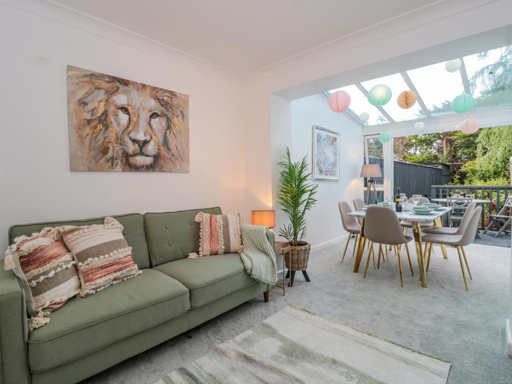 a living room with a green couch and a table at Forever Summer in Lymington
