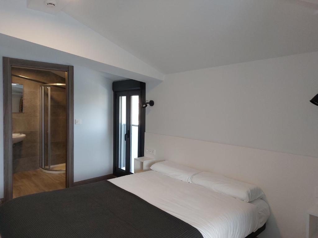 A bed or beds in a room at Pensión Amorrortu Lemona