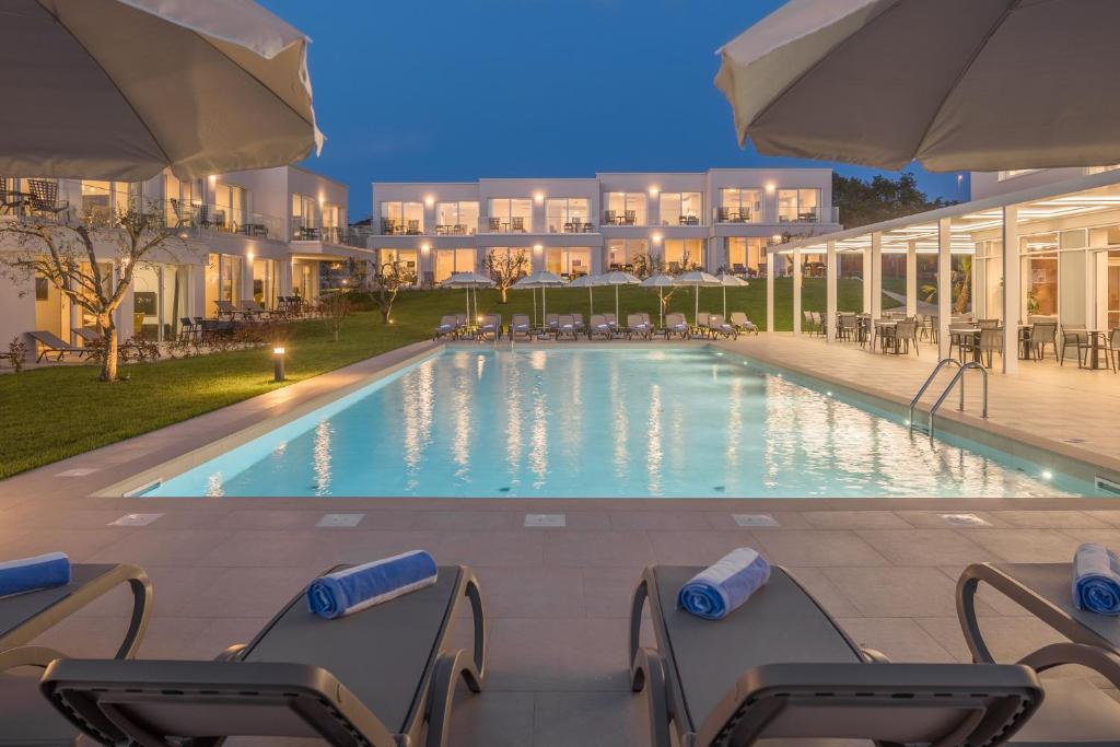a pool at a hotel with chairs and umbrellas at Maj Luxury Residence in Poreč