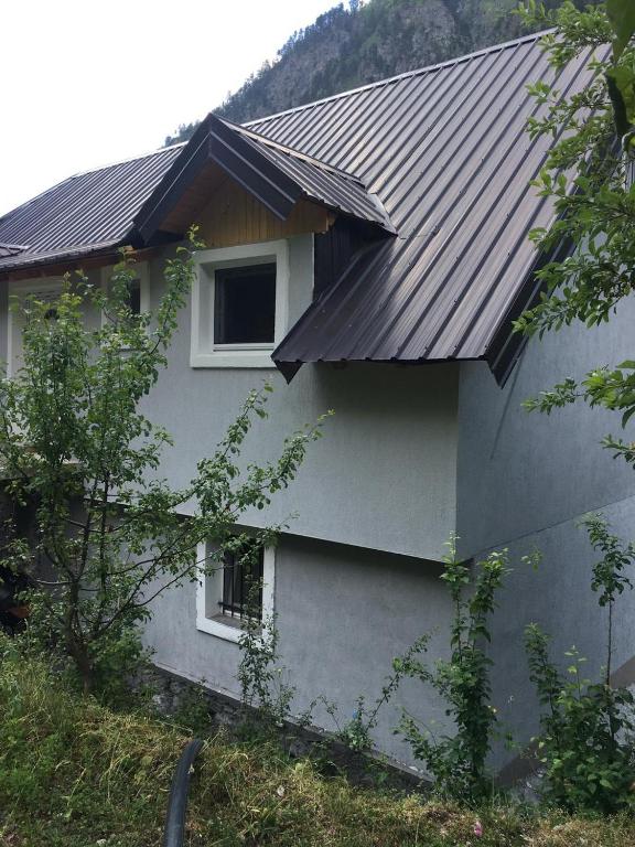 a house with a metal roof and two windows at Bujtina Sherifaj in Valbonë