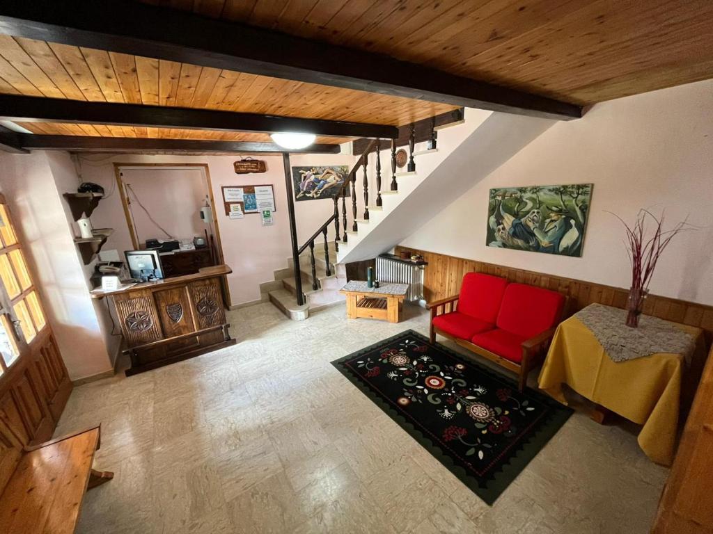 vista sul soffitto di un soggiorno con divano rosso di Claudia B&B a Pescasseroli