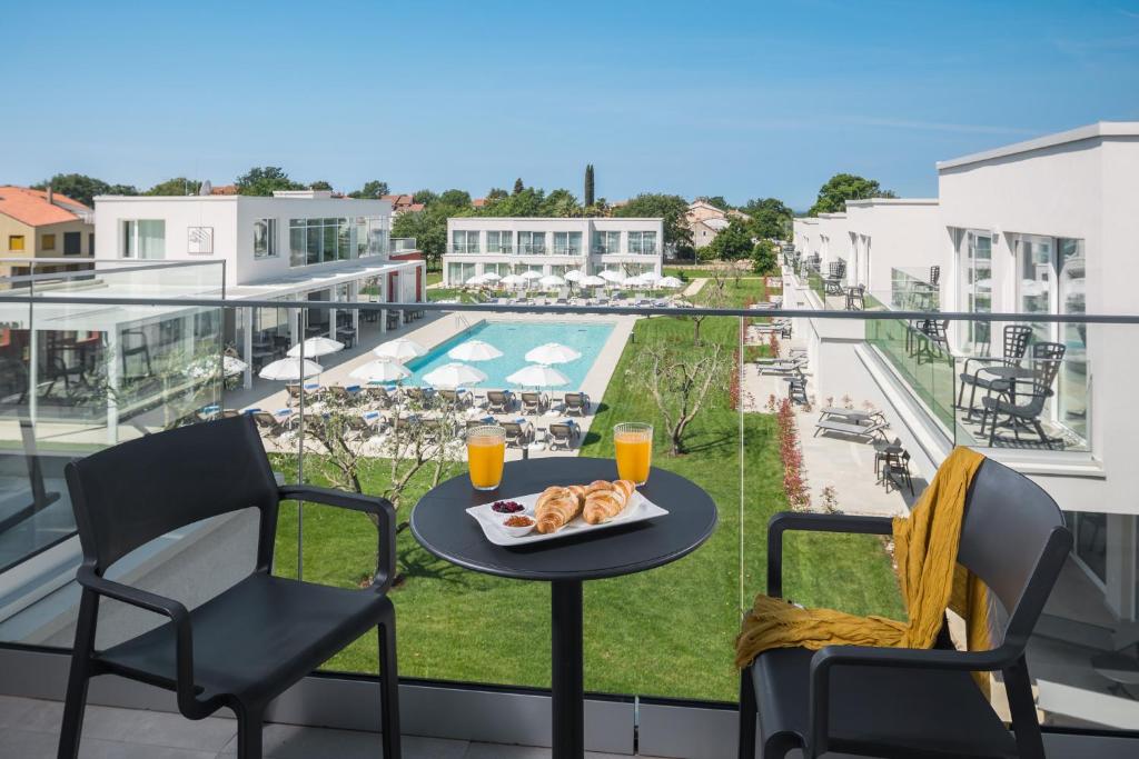a table with a plate of food on a balcony at Maj Luxury Residence in Poreč
