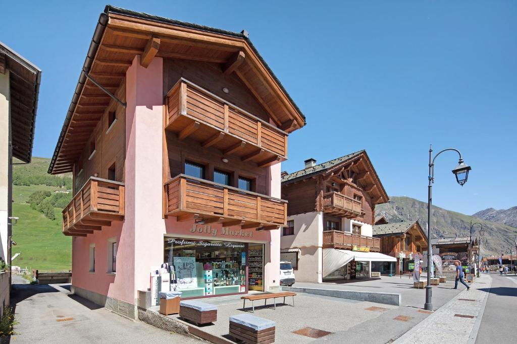 un bâtiment avec des balcons en bois dans une rue dans l'établissement Appartamento Jolly, à Livigno