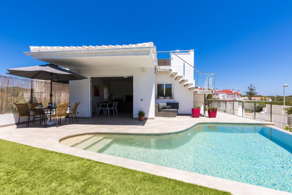 een villa met een zwembad en een patio bij Villa Vistamar in Punta Grossa