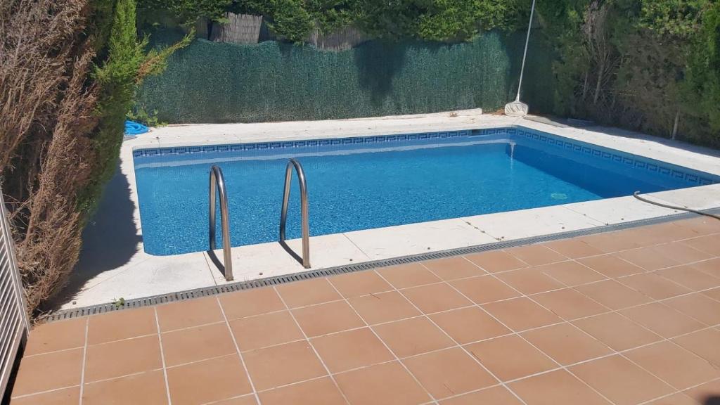 una piscina con ringhiere metalliche in un cortile posteriore di La Palmera a Estepona