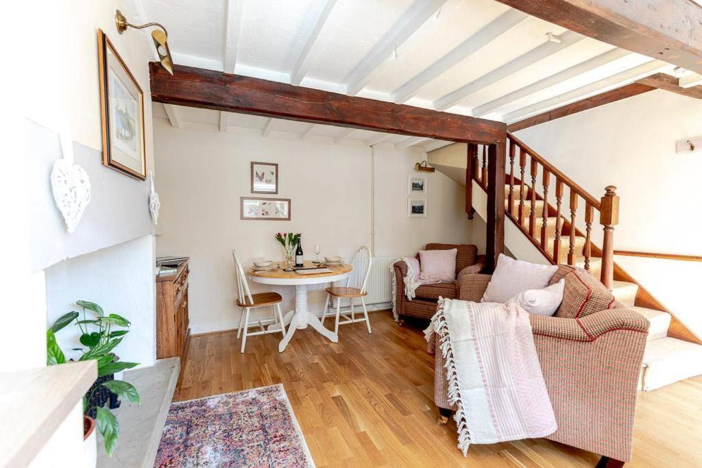 ein Wohnzimmer mit einem Tisch und einem Sofa in der Unterkunft FRANCE FOLD COTTAGE - Cosy 1 Bed Cottage Close to Holmfirth & the Peak District, Yorkshire in Honley