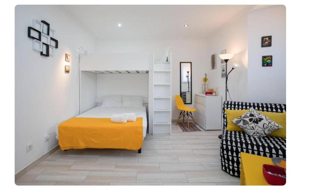 um quarto com uma cama e um sofá num quarto em BeGuest Casetta Cleo em Albufeira