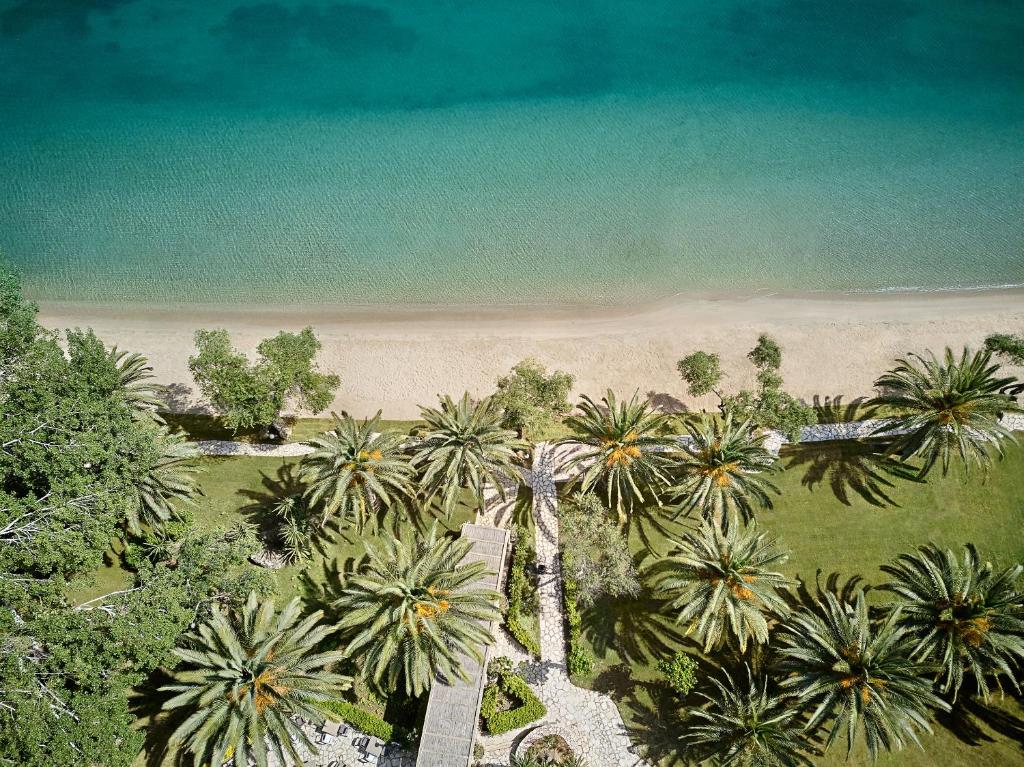 an overhead view of a beach with palm trees and the ocean at Grecotel-LUXME Daphnila Bay Dassia in Dassia