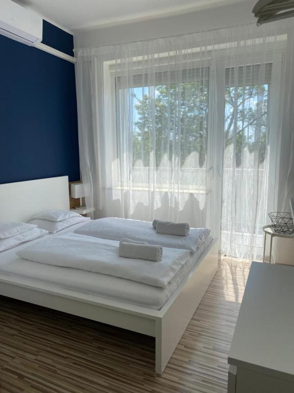 Un pat sau paturi într-o cameră la Élmény Balaton Hotel