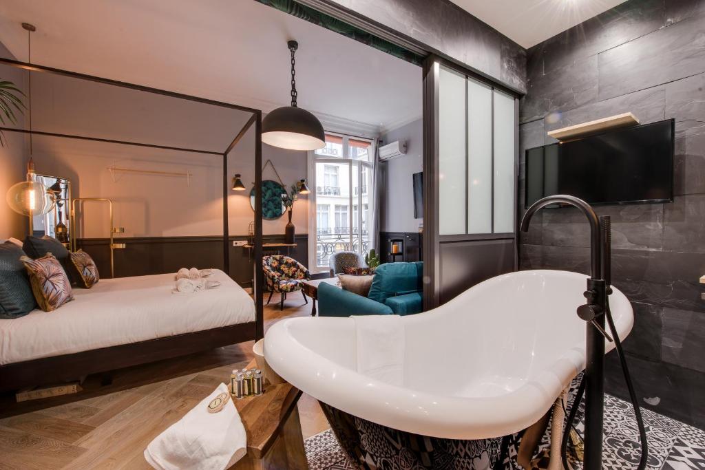 The Royal Elysée Suite في باريس: حمام مع سرير ومغسلة في الغرفة