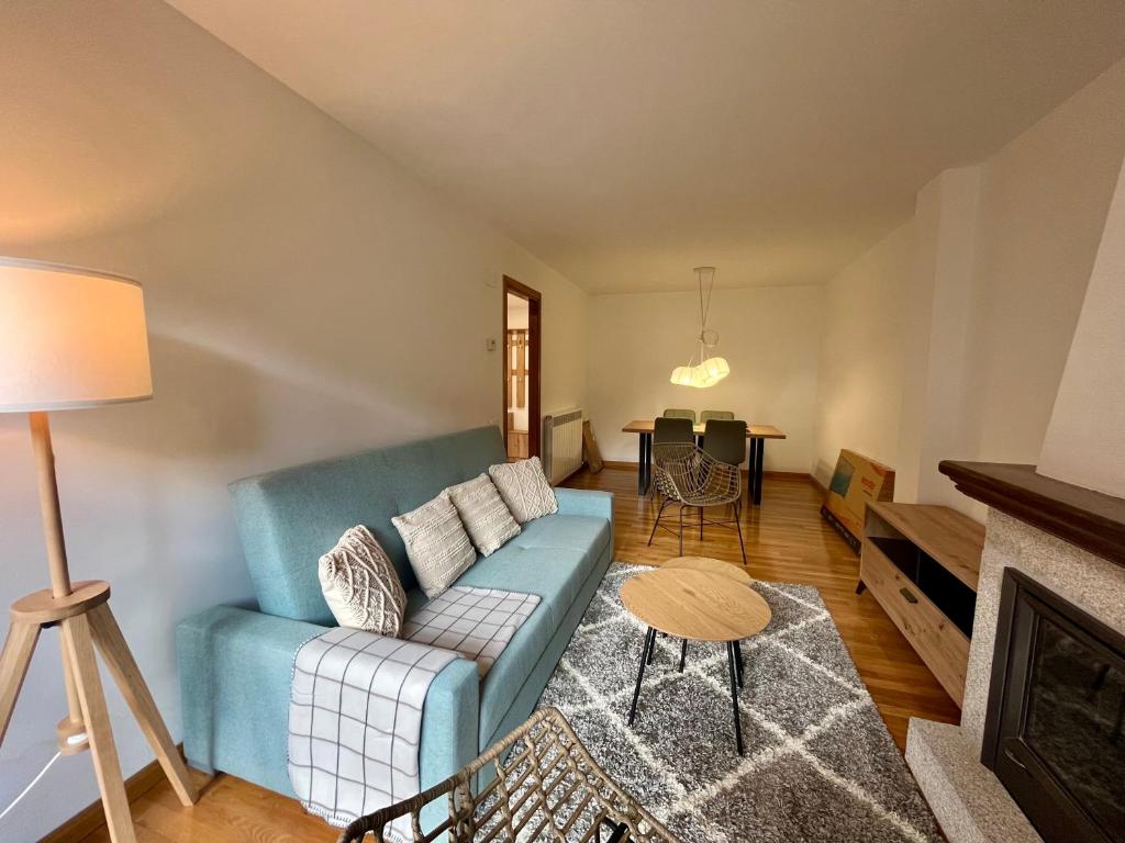 a living room with a blue couch and a table at BPIRINEOS-Parque Los Tilos 2 in Benasque