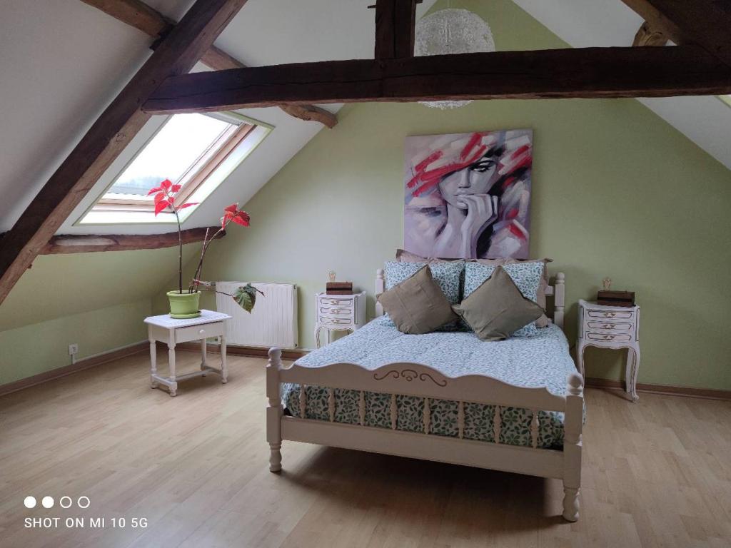 Schlafzimmer mit einem Bett mit Wandgemälde in der Unterkunft L'ancien café in Brocourt