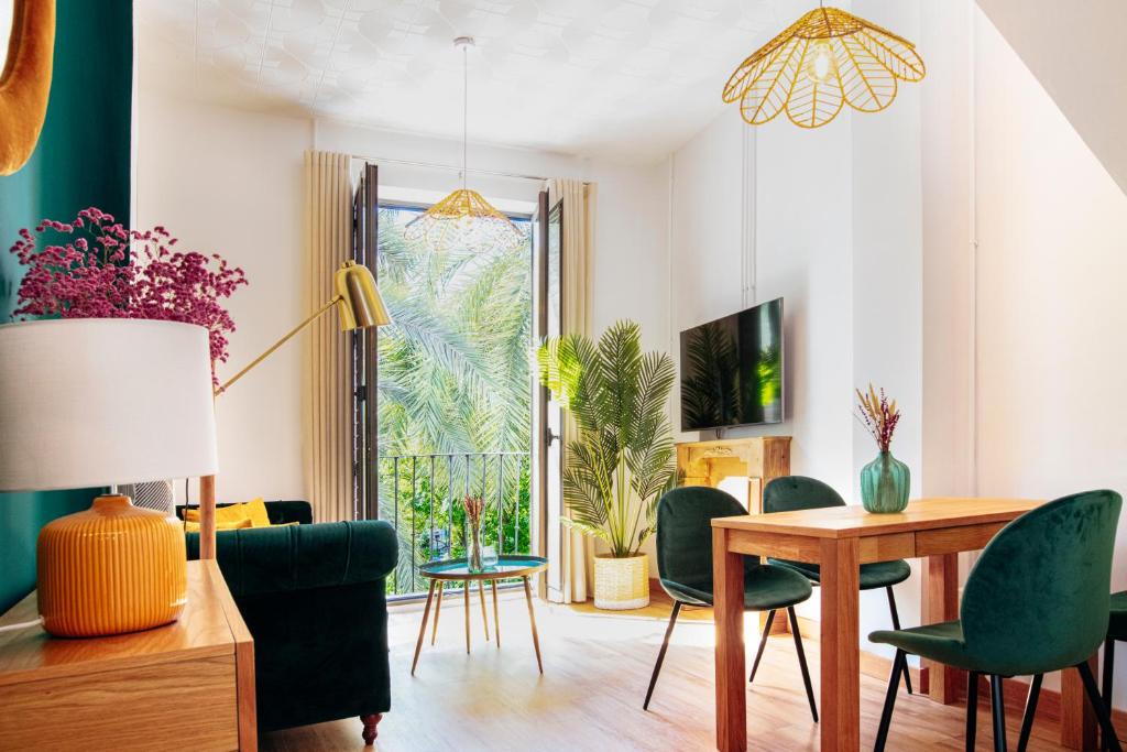 een woonkamer met een tafel en groene stoelen bij Casa de la Romanilla in Granada