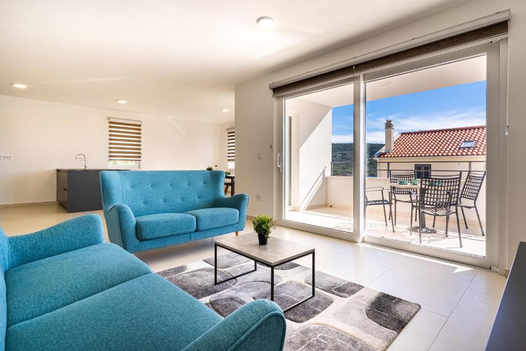 a living room with a blue couch and a table at Apartman Vischetti in Cres