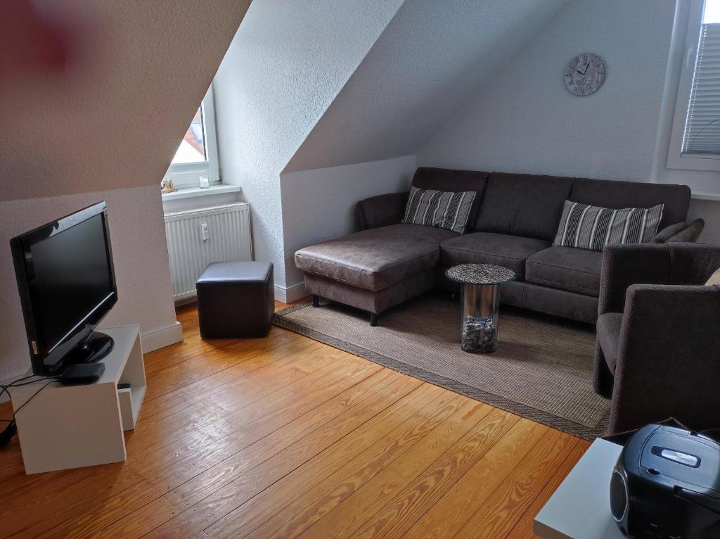 ein Wohnzimmer mit einem Sofa und einem TV in der Unterkunft Haus Sommerwind in Norderney
