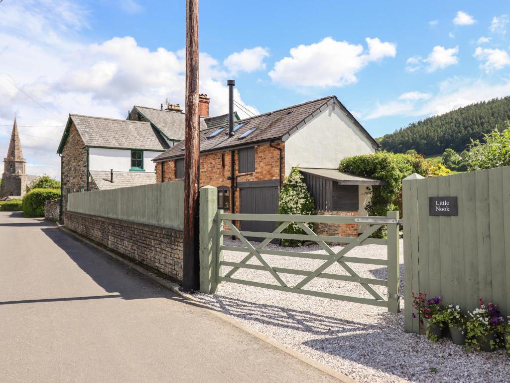 a house with a wooden gate and a fence at Little Nook in Corwen